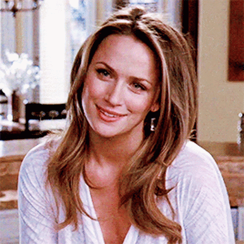 Woman Smiling in White Shirt and Earrings