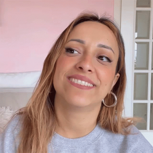Woman Smiling Wearing Hoop Earrings and Grey Sweatshirt