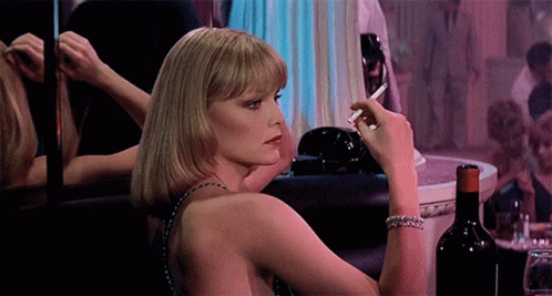 Woman Smoking Cigarette in Front of Mirror