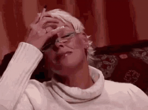 Woman Smoking on Couch Rubbing Forehead