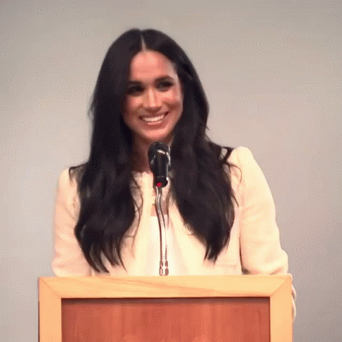 Woman Speaking Into Microphone at Podium