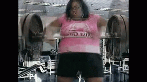 Woman Squatting With Barbell in Gym