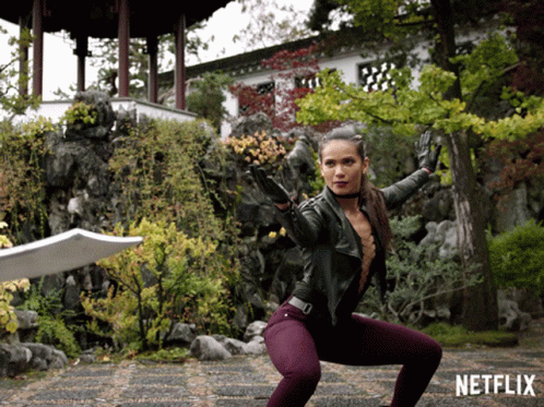 Woman Squatting With Sword In Front Of Netflix Sign GIF