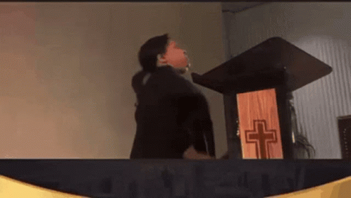 Woman Standing at Podium with Wooden Cross