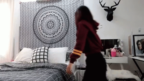 Woman Standing Before Bed with Mandala Tapestry