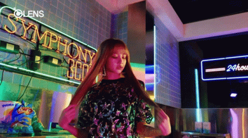 Woman Standing Before Symphony 360 Neon