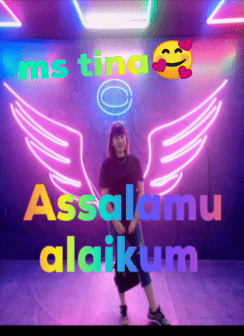 Woman Standing by Assalamu Alaikum Neon Sign