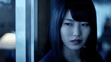 Woman Standing by Window in Dark Room