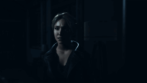 Woman Standing In Dark Room Looking Out Doorway GIF