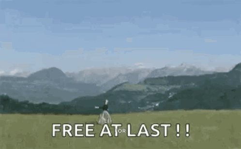 Woman Standing in Field with Mountains Free at Last