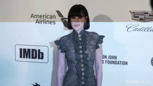 Woman Standing In Front Of American Airlines And IMDb Wall GIF