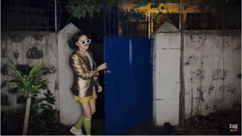 Woman Standing In Front Of Fame Gate GIF