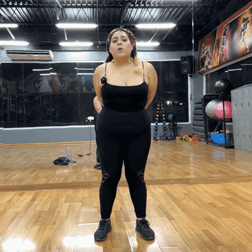 Woman Standing In Front Of Gym Mirror GIF