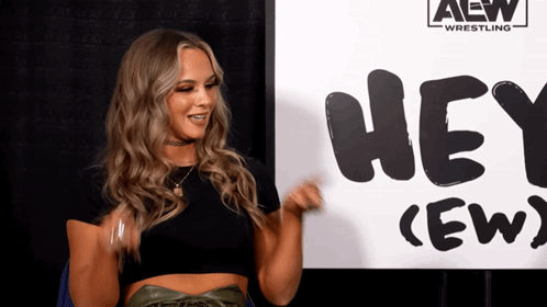 Woman Standing in Front of Hey Crew Sign