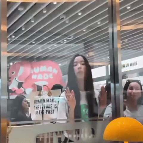 Woman Standing in Front of Human Made Sign
