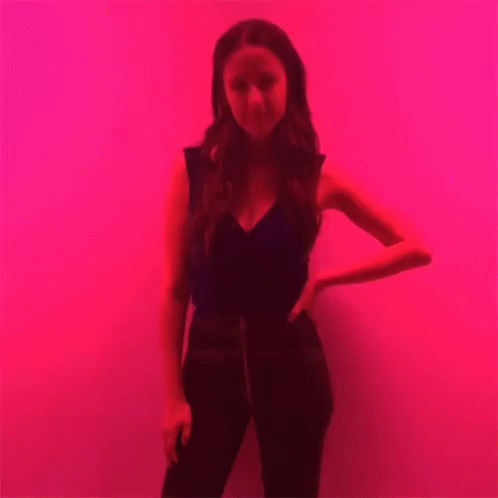 Woman Standing In Front Of Red Wall GIF