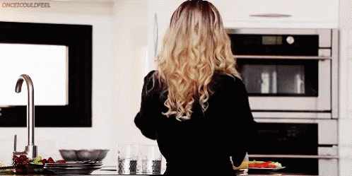 Woman Standing In Kitchen With Plate Of Food GIF