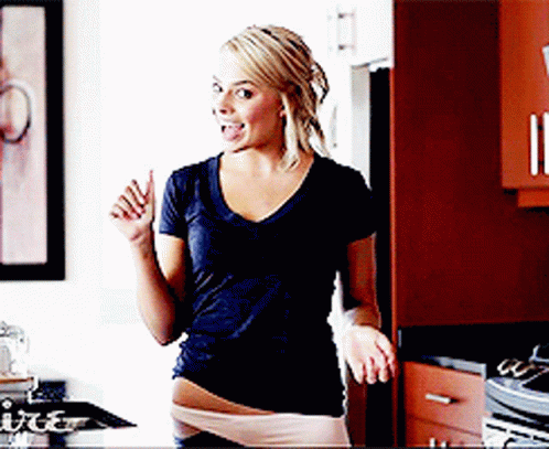 Woman Standing In Kitchen With Tongue Out GIF