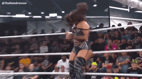 Woman Standing in Wrestling Ring Before Crowd