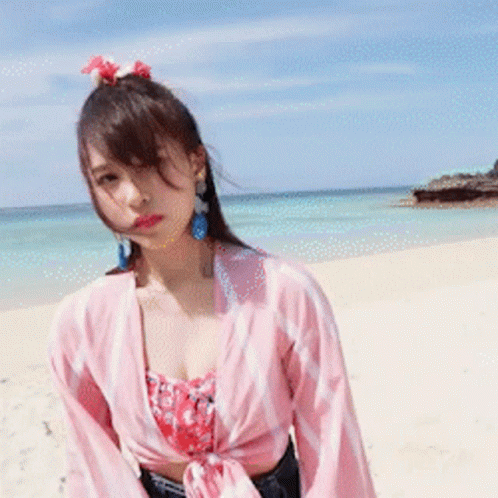 Woman Standing On Beach In Pink Shirt GIF