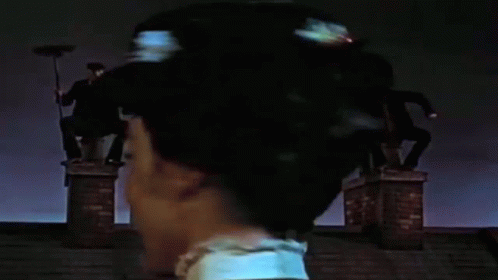 Woman Standing on Chimney with Broom in Hair