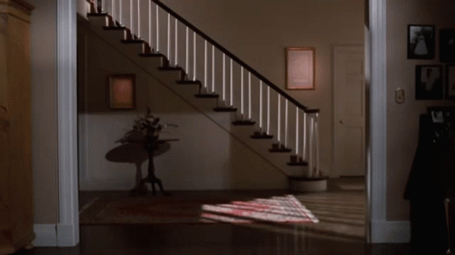 Woman Standing On One Leg In Front Of Staircase GIF