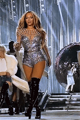 Woman Standing on Stage in Jumpsuit and Boots