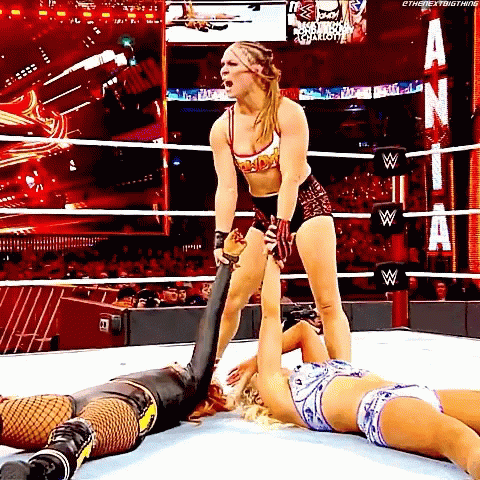 Woman Standing Over Another in Wrestling Ring