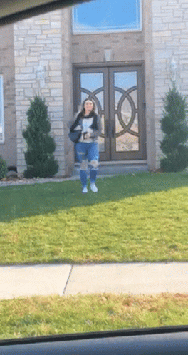 Woman Stands in Front of Brick House