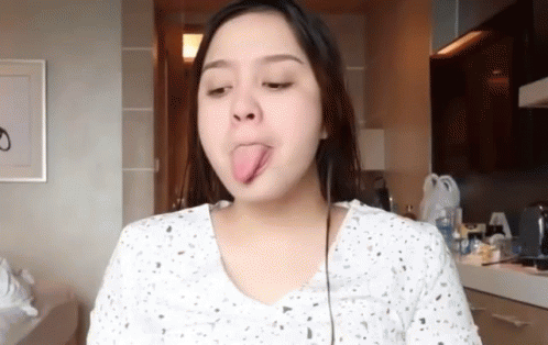 Woman Sticking Tongue Out In Kitchen GIF