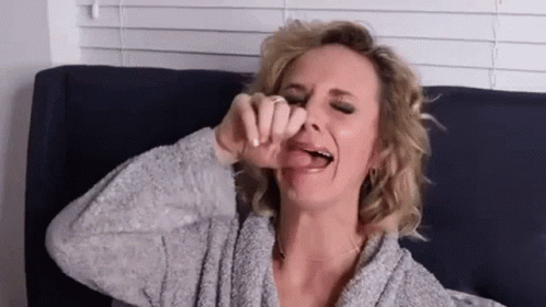 Woman Sticking Tongue Out On Couch GIF