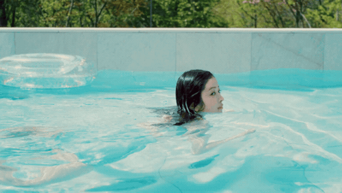 Woman Swimming in Pool With Life Preserver