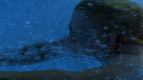 Woman Swimming Underwater in Blue Pool