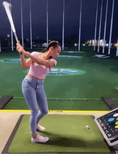 Woman Swinging Golf Club At Golf Ball GIF