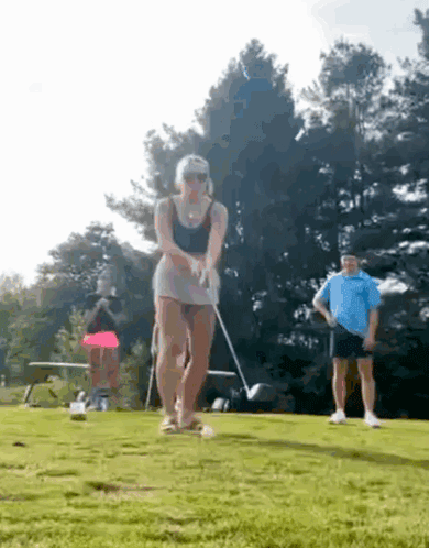 Woman Swinging Golf Club on Course