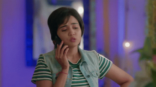 Woman Talking on Cell Phone in Striped Shirt and Denim Vest