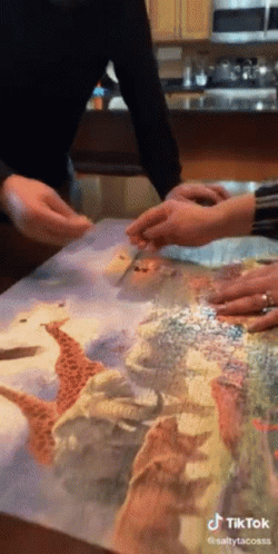 Woman Throwing Completed Jigsaw Puzzle Off Table GIF