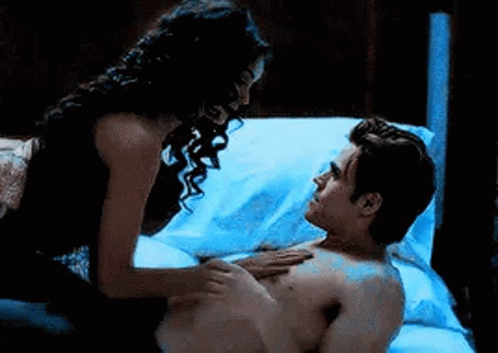 Woman Touching Man's Chest on Bed
