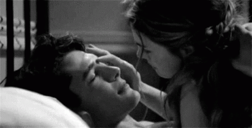 Woman Touching Man's Forehead In Bed GIF