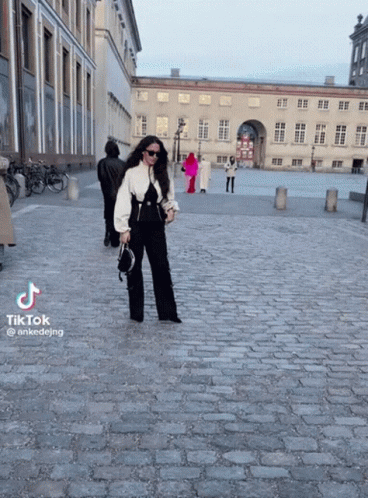 Woman Walking Cobblestone Street