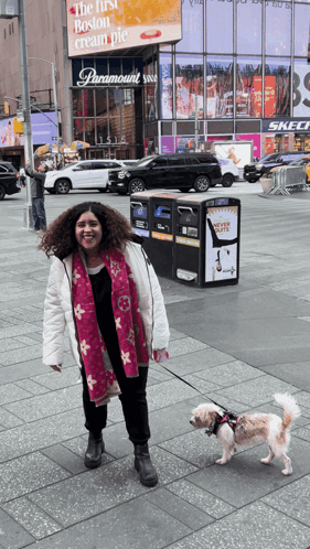 Woman Walking Dog in Front of Paramount Sign