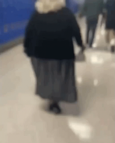 Woman Walking Down Hallway