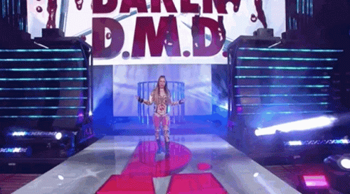Woman Walking Down Stage With D M D Sign
