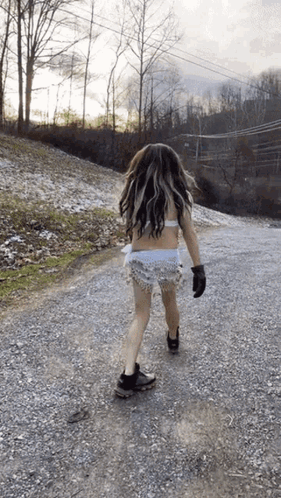 Woman Walking Gravel Road in Bikini Top and Shorts