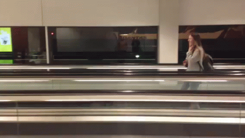 Woman Walking on Escalator Past Qantas Sign