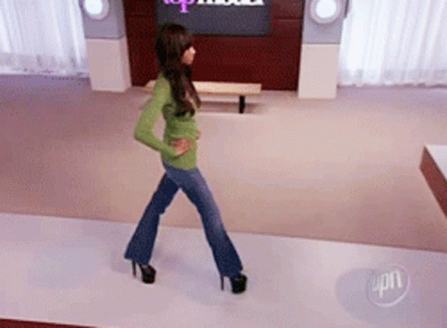 Woman Walking Runway in Front of Top Model Sign