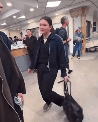 Woman Walking With Bag in Hospital Lobby