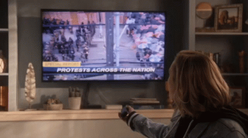 Woman Watching Protests on TV