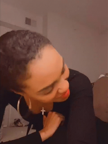 Woman Wearing Black Shirt and Cross Necklace Making Funny Face