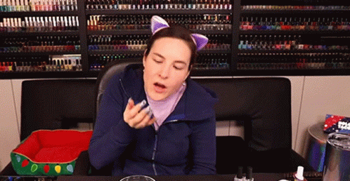 Woman Wearing Cat Ears in Front of Nail Polish Wall